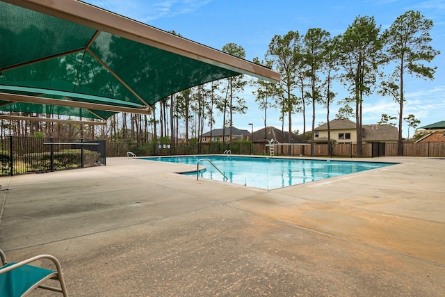 community pool with a patio and fence