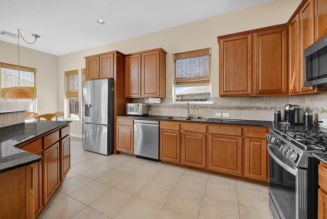 kitchen with brown cabinets, appliances with stainless steel finishes, and a sink