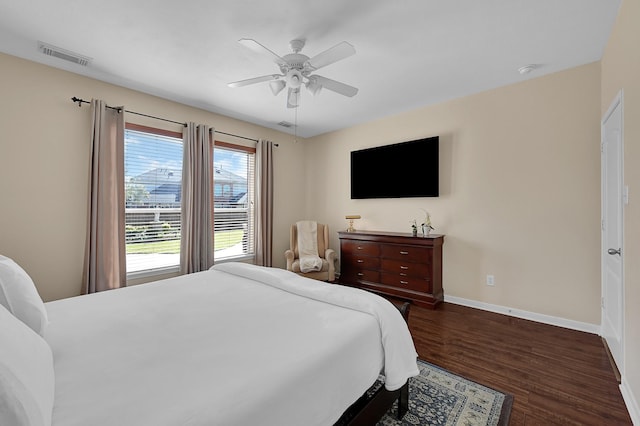 bedroom featuring visible vents, baseboards, dark wood finished floors, and a ceiling fan