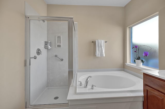 full bathroom featuring a bath, a shower stall, and vanity