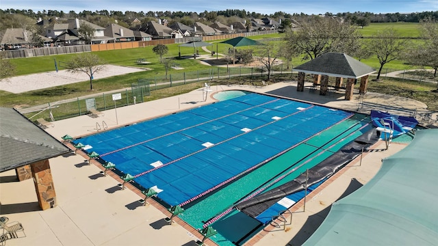 view of swimming pool with a gazebo, fence, a residential view, and a patio area