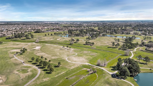 birds eye view of property with golf course view and a water view