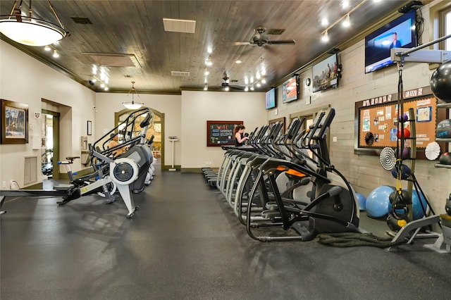 exercise room featuring visible vents, ceiling fan, wooden ceiling, and baseboards