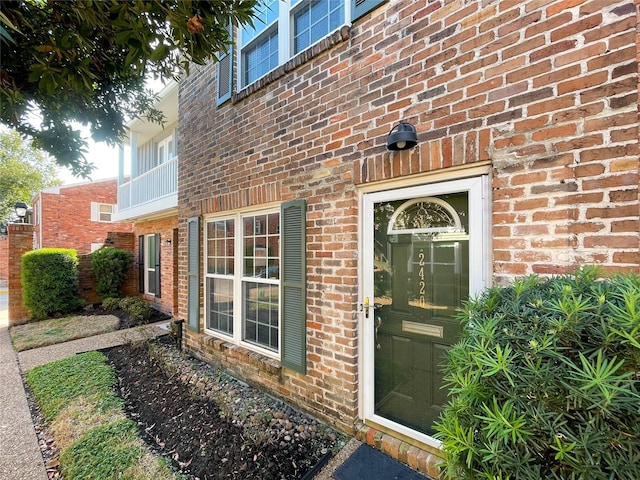 doorway to property featuring brick siding