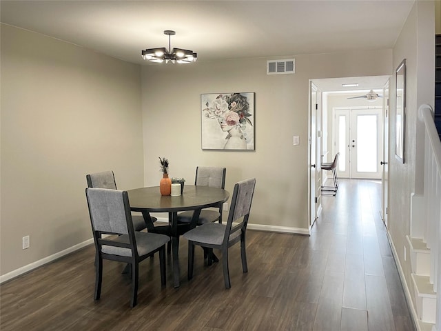 dining space featuring a chandelier, visible vents, dark wood-type flooring, and baseboards