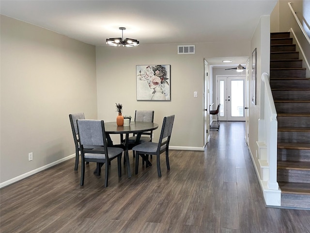 dining room featuring dark wood-style floors, visible vents, french doors, and stairs