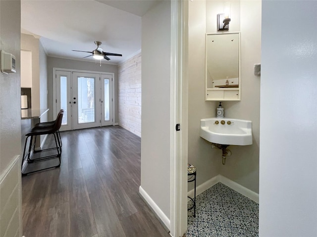 bathroom featuring ornamental molding, a ceiling fan, a sink, wood finished floors, and baseboards