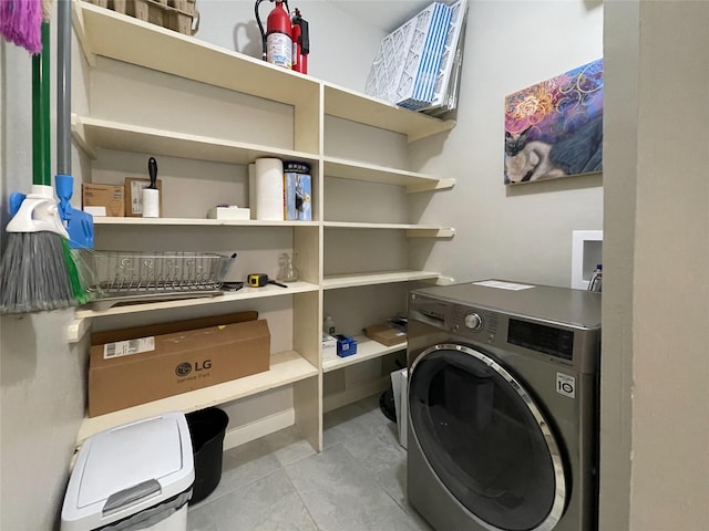 washroom featuring separate washer and dryer, laundry area, and tile patterned flooring