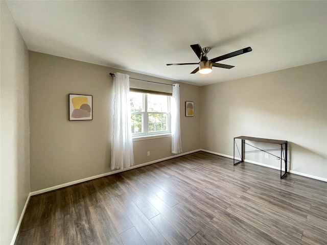 empty room with ceiling fan, baseboards, and wood finished floors