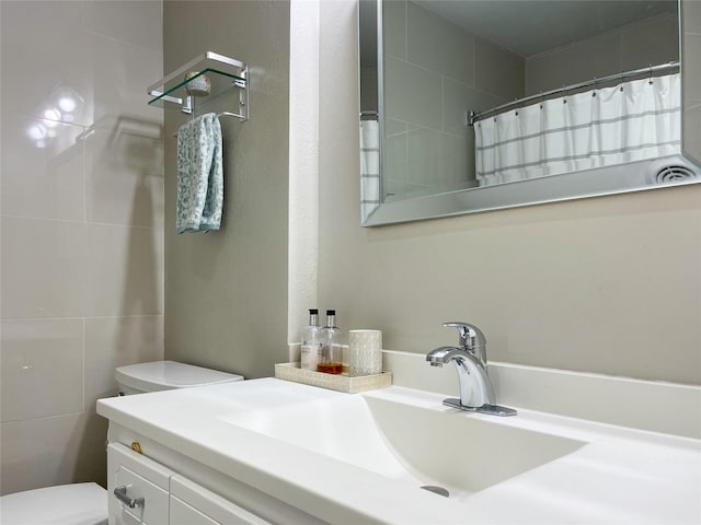 bathroom featuring curtained shower, toilet, and vanity