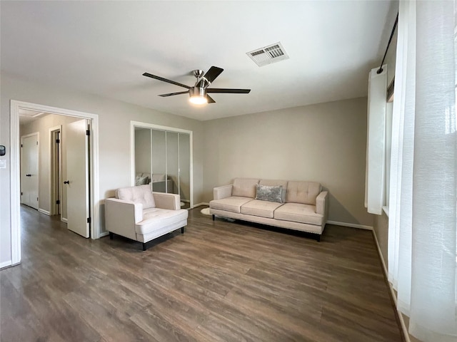 living room with a ceiling fan, dark wood-style floors, visible vents, and baseboards