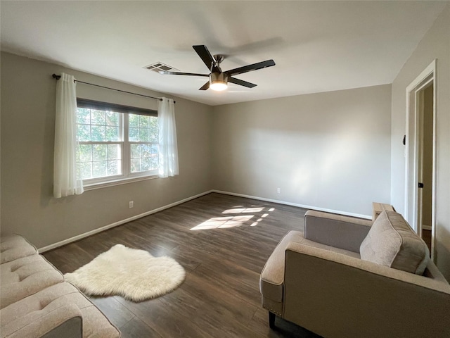 interior space featuring visible vents, a ceiling fan, dark wood-type flooring, and baseboards