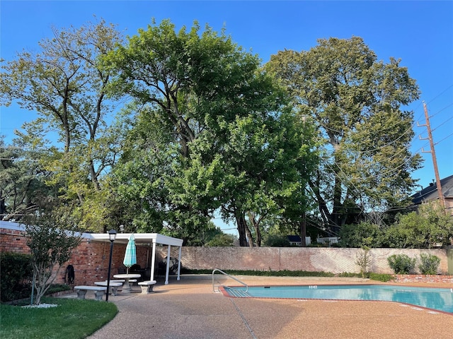 view of swimming pool featuring fence