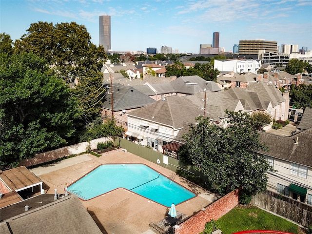 pool with a city view, a patio area, and a fenced backyard