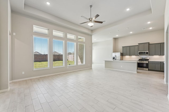 unfurnished living room with recessed lighting, baseboards, light wood-style floors, and ceiling fan