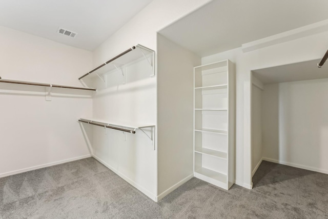 walk in closet featuring light carpet and visible vents