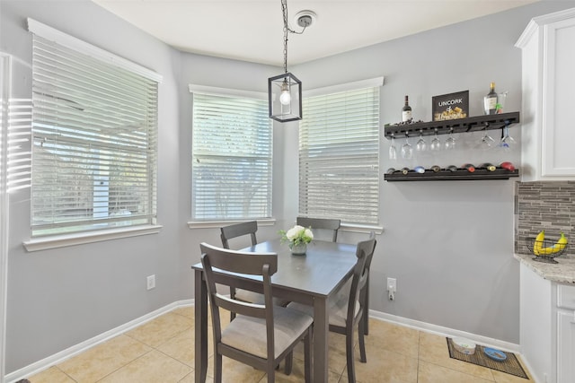 dining space with baseboards and light tile patterned flooring