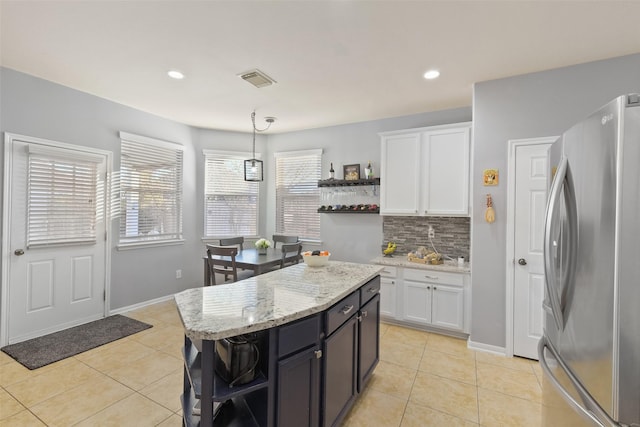 kitchen featuring light tile patterned floors, white cabinets, freestanding refrigerator, and open shelves