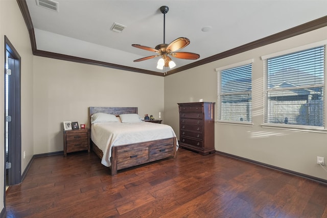 bedroom with wood finished floors, visible vents, and ornamental molding