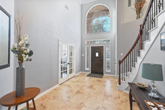 foyer entrance featuring french doors, baseboards, and stairway