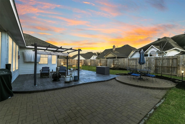 patio terrace at dusk featuring a fenced backyard, a pergola, and a grill