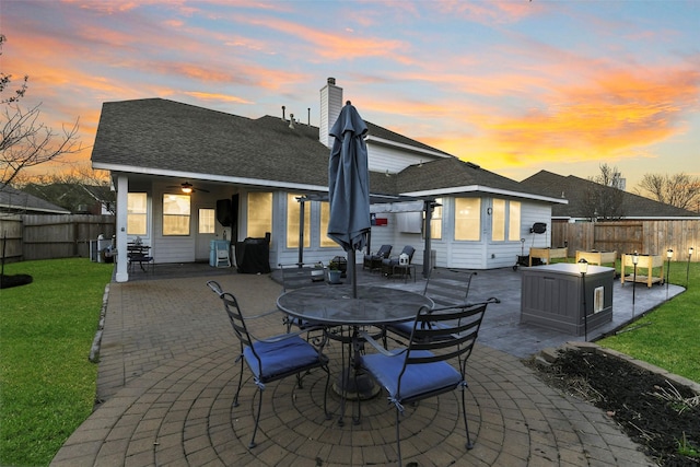 back of house featuring a yard, a patio, and a fenced backyard