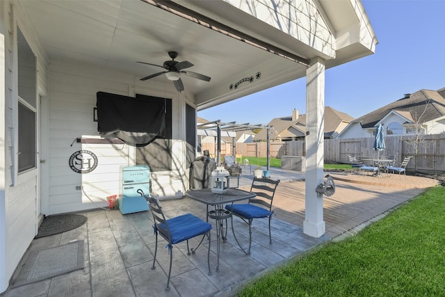 view of patio / terrace featuring a residential view, a fenced backyard, a ceiling fan, and outdoor dining space