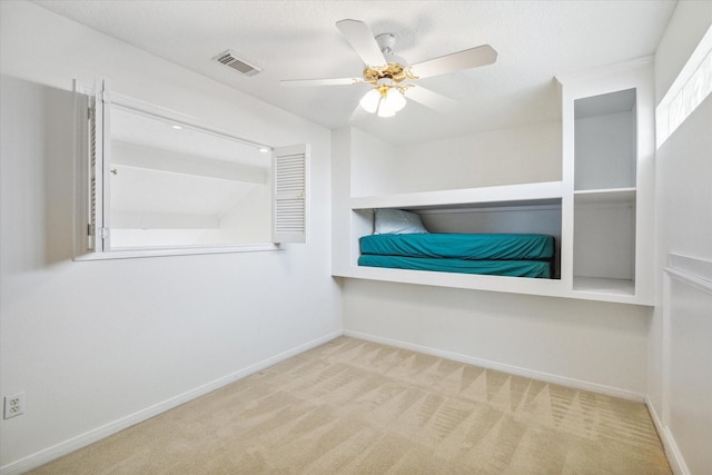 spacious closet featuring carpet flooring, visible vents, and ceiling fan