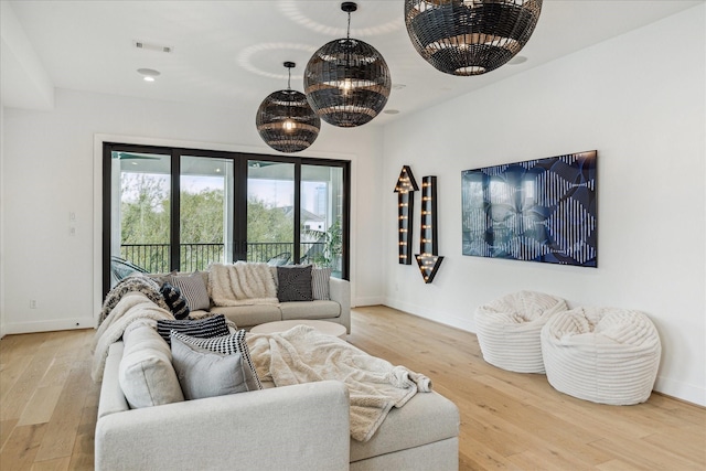 living area with visible vents, baseboards, and wood finished floors