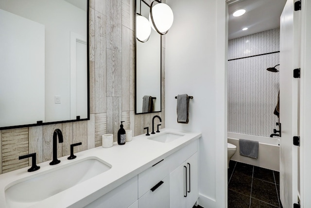 full bathroom with a sink, shower / bath combination, toilet, and double vanity