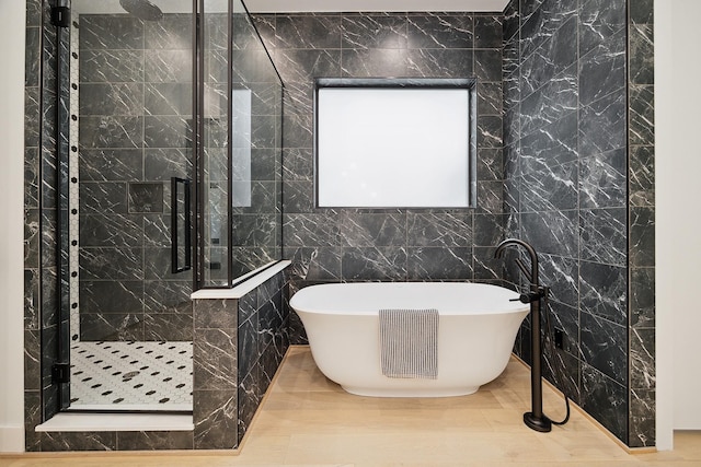 bathroom featuring a soaking tub, tile walls, and a shower stall