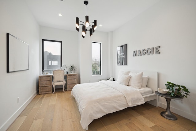 bedroom with multiple windows, baseboards, and light wood-type flooring