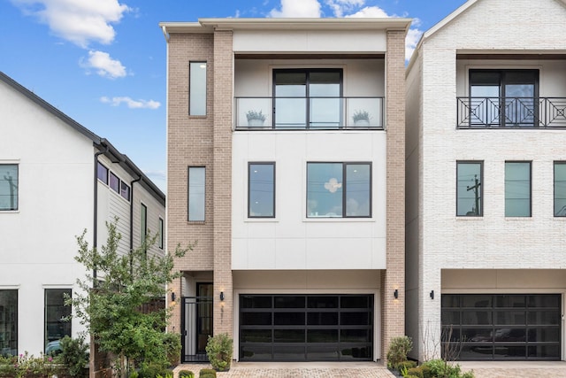 view of front of property with stucco siding, brick siding, and an attached garage