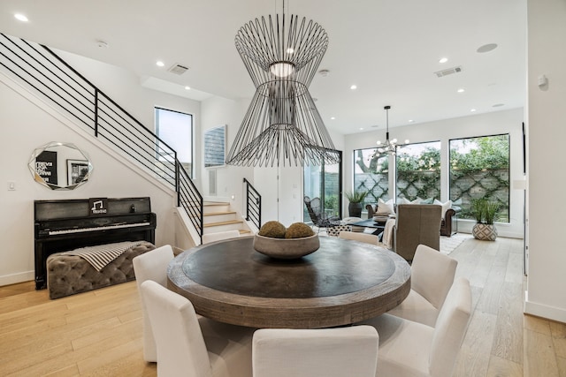 dining area with visible vents, stairs, recessed lighting, light wood-style flooring, and a notable chandelier