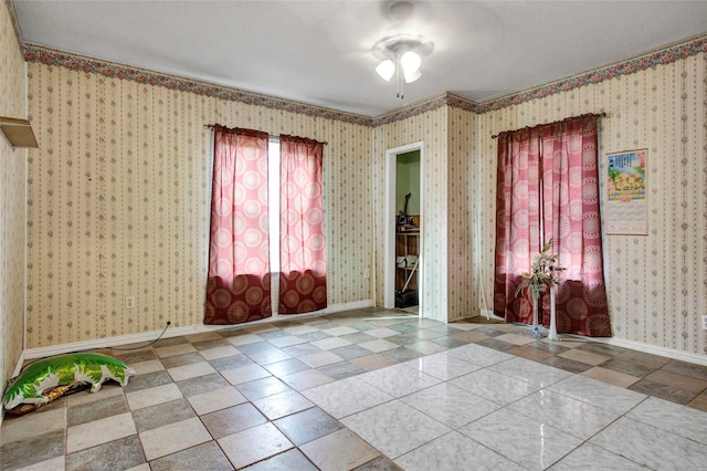 empty room with ceiling fan, wallpapered walls, and baseboards