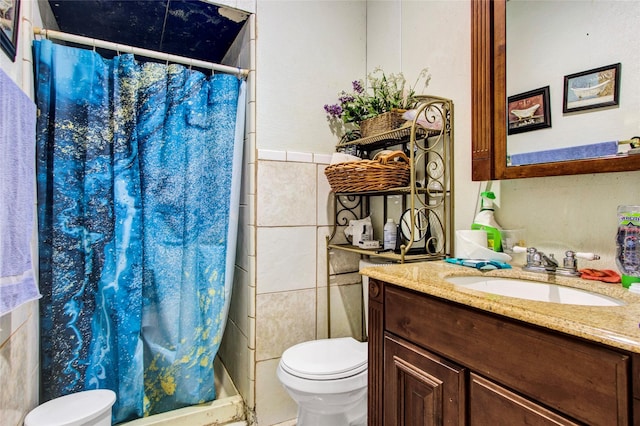 full bathroom with curtained shower, toilet, tile walls, and vanity