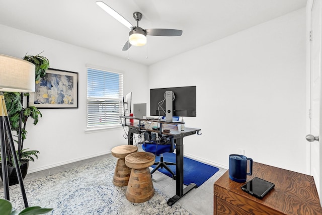 office space with baseboards, a ceiling fan, and tile patterned flooring