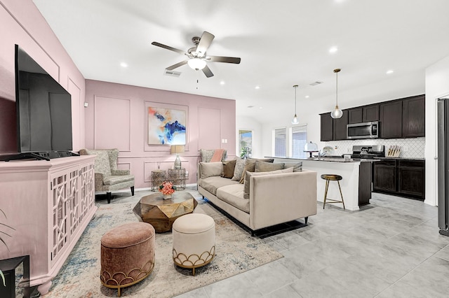 living room with a decorative wall, recessed lighting, a ceiling fan, and visible vents