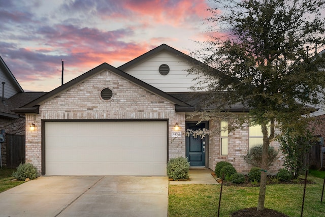 view of front of house with an attached garage, brick siding, and driveway