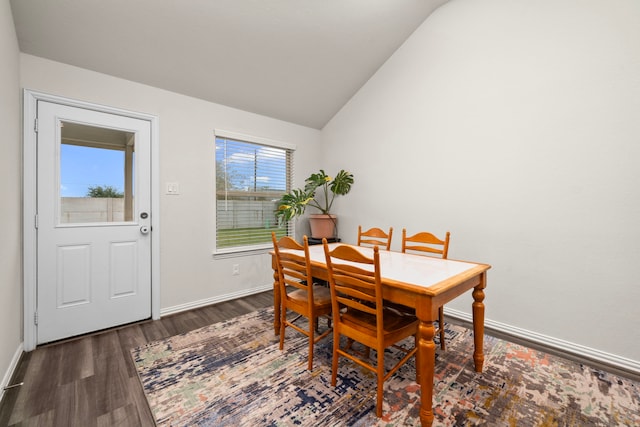 dining room with baseboards, lofted ceiling, and wood finished floors