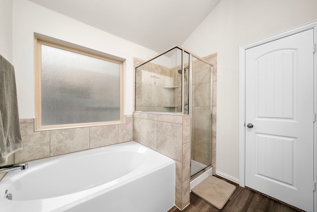 bathroom featuring a shower stall, a garden tub, and wood finished floors