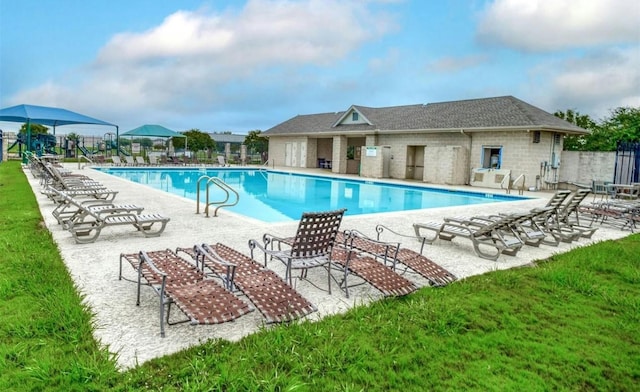 pool with a patio area, a yard, and fence