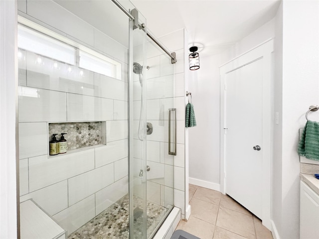 full bathroom featuring tile patterned flooring, baseboards, and a stall shower