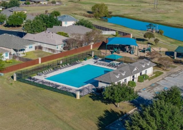 view of pool featuring fence and a water view