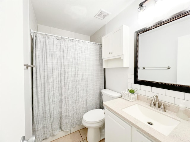 bathroom featuring vanity, visible vents, tile patterned flooring, toilet, and tasteful backsplash