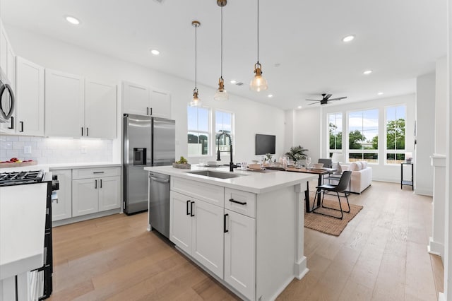 8305 Springwood Creek Ln, Houston, TX 77055 - kitchen featuring appliances with stainless steel finishes, plenty of natural light, light wood-style floors, ceiling fan, and recessed lighting