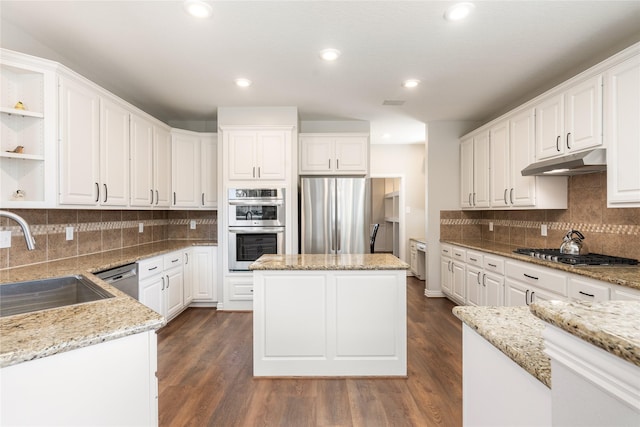 kitchen featuring under cabinet range hood, stainless steel appliances, white cabinetry, and a sink