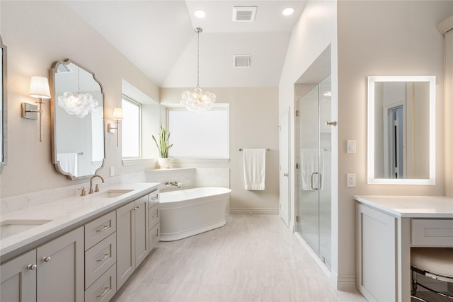 bathroom featuring a sink, visible vents, a chandelier, and vaulted ceiling