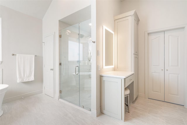 bathroom featuring a stall shower, vanity, and baseboards