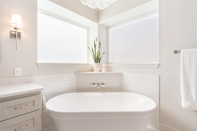 full bathroom with a freestanding bath and vanity